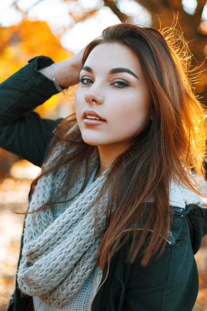 Portret van een jonge mooi meisje in een gebreide trui op een zonnige herfstdag - Foto, afbeelding