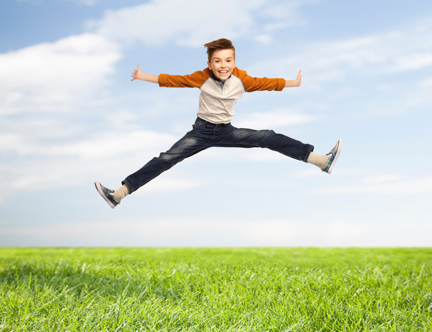 happy smiling boy jumping in air - Фото, изображение