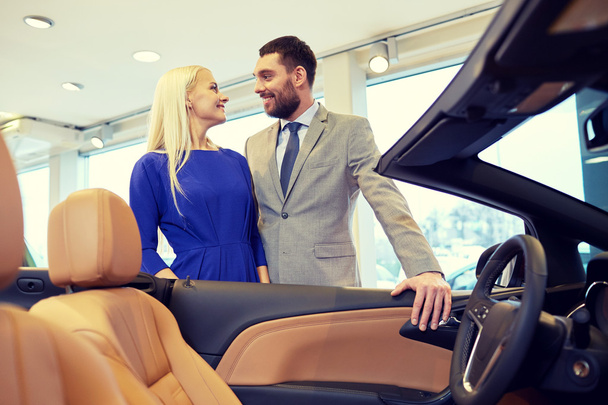 happy couple buying car in auto show or salon - Fotografie, Obrázek