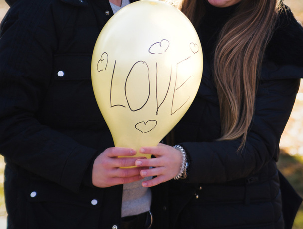 Jovem casal feliz segurando balão amarelo
 - Foto, Imagem