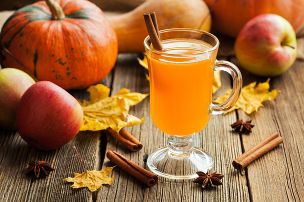 Hot apple cider healthy traditional winter christmas or thanksgiving holiday beverage. Sweet organic autumn drink with spices, cinnamon and anise on vintage wooden background. - Photo, Image