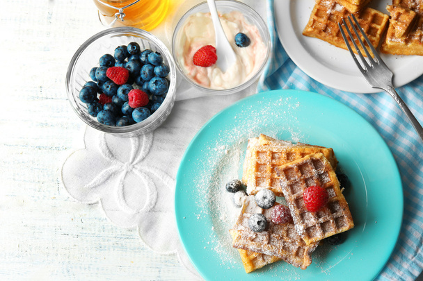 Sweet homemade waffles with forest berries on plate, on light background - Foto, Imagem
