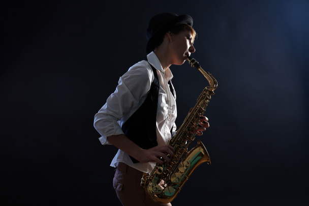 Attractive woman plays saxophone  - Фото, изображение