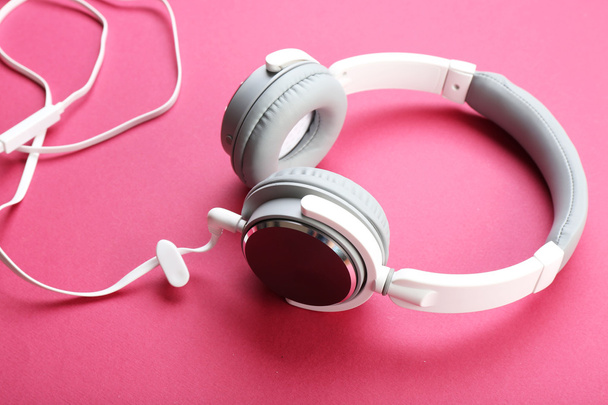 Bílé a šedé sluchátka na růžovém pozadí - Fotografie, Obrázek