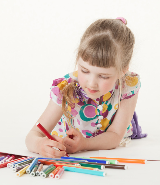 Маленькая девочка рисует и лежит на полу
 - Фото, изображение