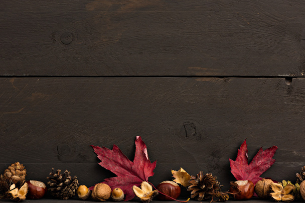 Wooden autumn background with chestnuts and foliage - 写真・画像
