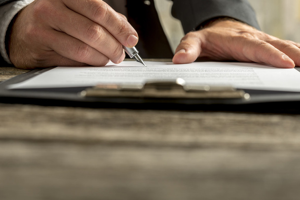 Gros plan de l'homme d'affaires signant un contrat, un document ou un document juridique
 - Photo, image