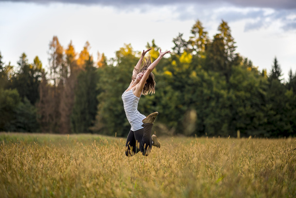 fröhliche, fröhliche junge Frau springt mitten in der Luft - Foto, Bild
