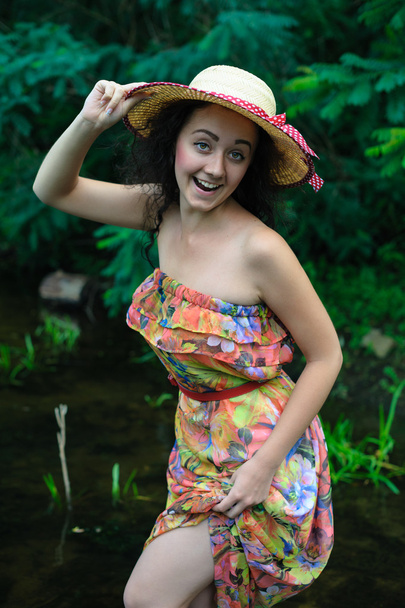 belle fille avec un chapeau se tient dans la rivière
. - Photo, image