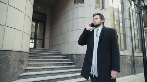 όμορφος επιχειρηματίας, μιλώντας στο τηλέφωνο στο κέντρο της πόλης - Πλάνα, βίντεο