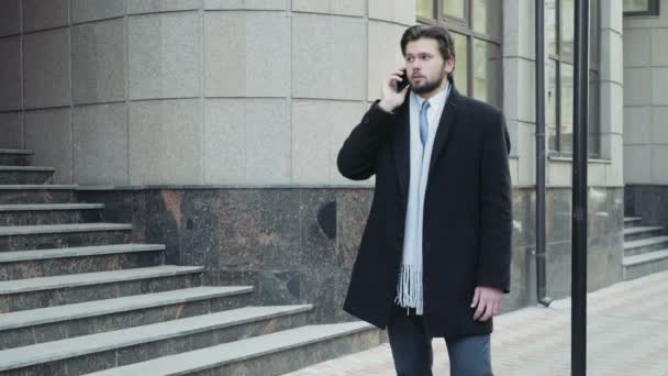 Bonito homem de negócios falando ao telefone no centro da cidade
 - Filmagem, Vídeo