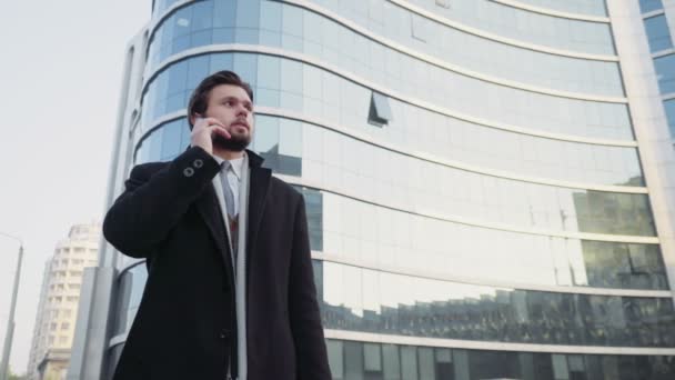 hombre de negocios guapo hablando por teléfono en el centro de la ciudad
 - Imágenes, Vídeo