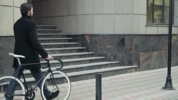 hombre de negocios guapo caminando con su bicicleta en el centro de la ciudad
 - Imágenes, Vídeo