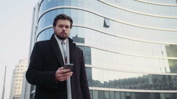 hombre de negocios guapo usando un teléfono inteligente en el centro de
 - Metraje, vídeo