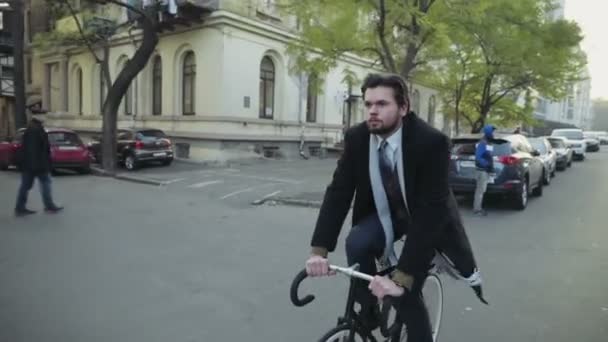 handsome businessman riding a bicycle in downtown slow motion - Footage, Video