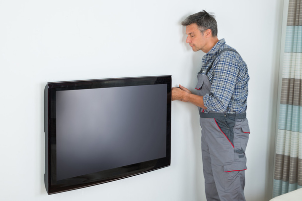 Technician Installing Television At Home - 写真・画像