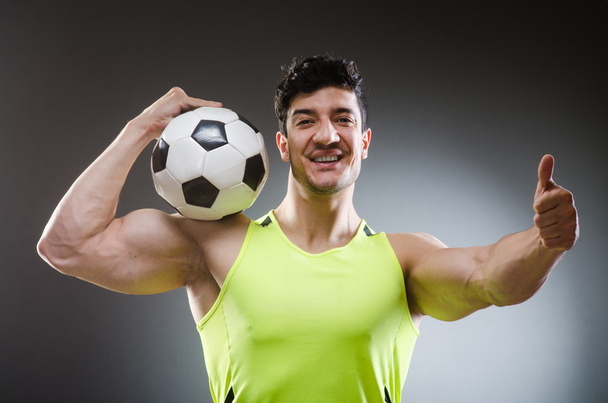 Muscular man with football ball - 写真・画像