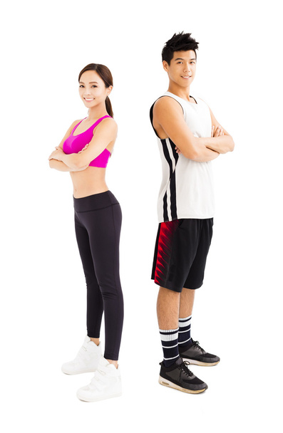 joven pareja de fitness de pie juntos aislados en blanco
 - Foto, Imagen