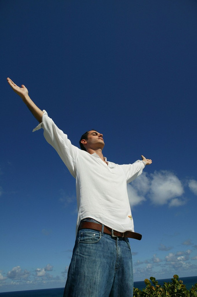 Man stood in field with his arms raised - Photo, Image