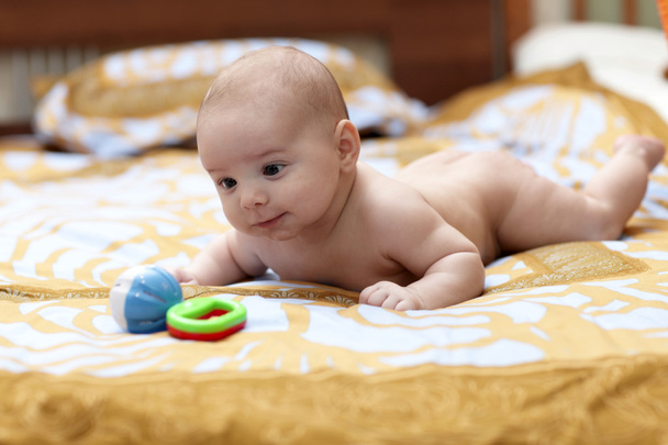 Happy baby looking at rattle - Photo, Image