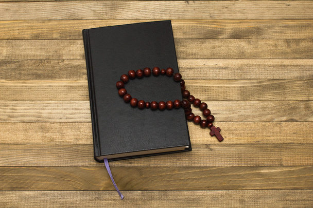 livre de bible et chapelet sur planches de bois foncé
 - Photo, image