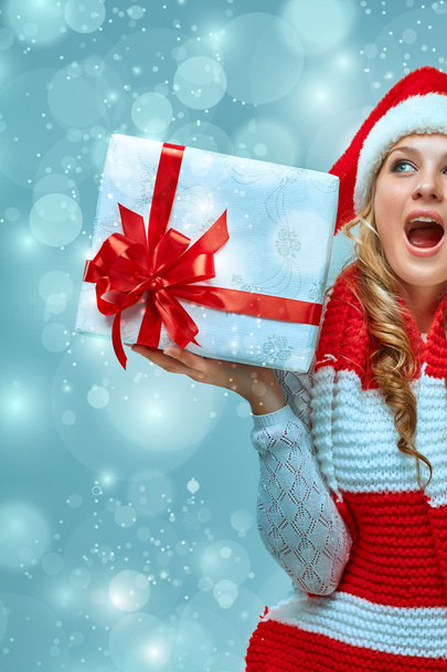 Girl dressed in santa hat with a Christmas gift - Foto, Imagen
