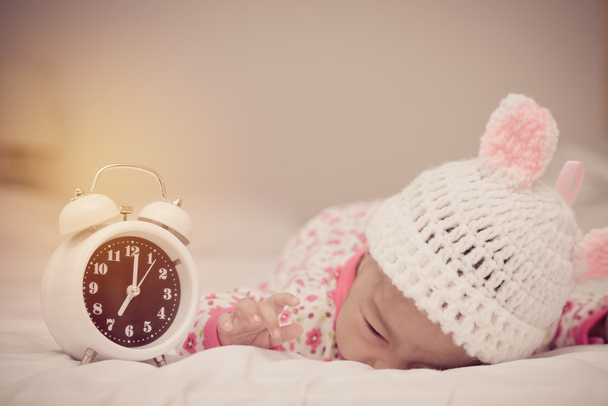 χαριτωμένο κοριτσάκι και ξυπνητήρι που ξυπνούν το πρωί - Φωτογραφία, εικόνα