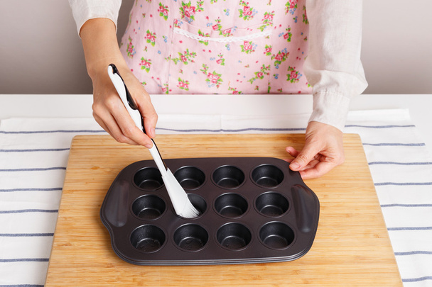 Жінка розкладає олію в сковороді
 - Фото, зображення