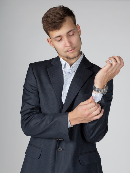 Young business man in suit straightens cuffs with care. - Foto, Imagen