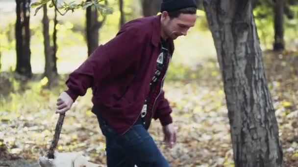 young man playing with two dogs in autumn park - Footage, Video
