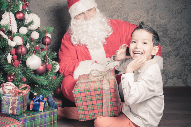 Merry Christmas! Happy boy and Santa Claus with gift box - Foto, Imagen