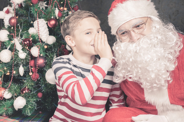 Little boy talk to Santa Claus wishlist, gifts, Christmas night - 写真・画像