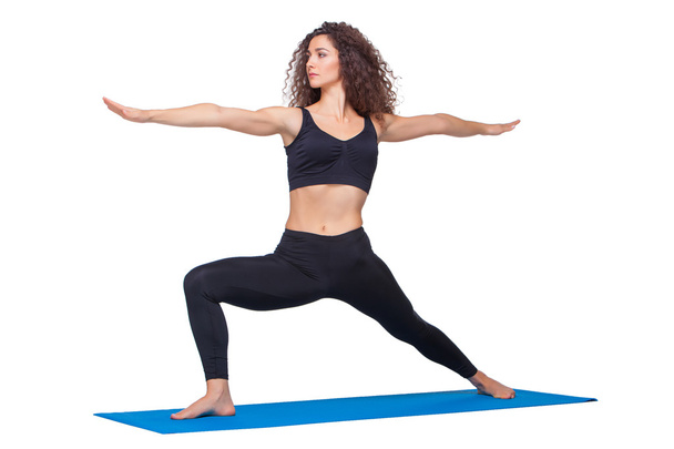Studio shot of a young fit woman doing yoga exercises. - Foto, afbeelding