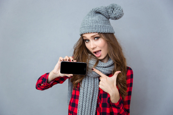 Woman pointing finger on blank smartphone screen - 写真・画像