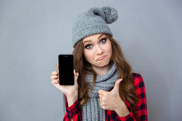 Woman showing blank smartphone screen and thumb up - Foto, Imagen
