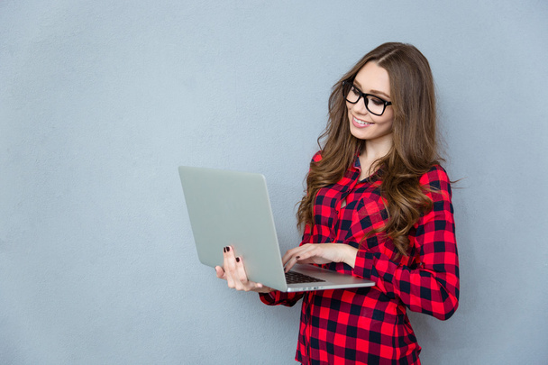 Beautiful girl in glasses using laptop - Photo, Image