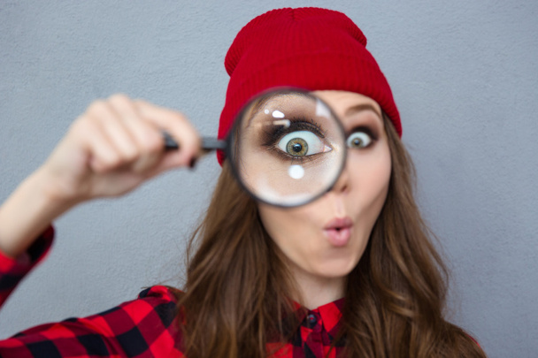 Woman looking at the camera through magnifying glass - Foto, Imagen