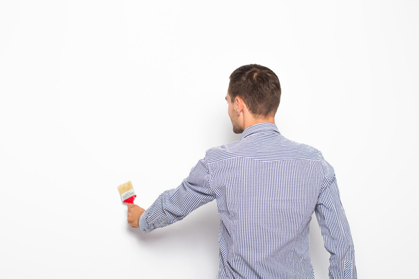 Workman and businessman painting white wall with brush - Fotoğraf, Görsel