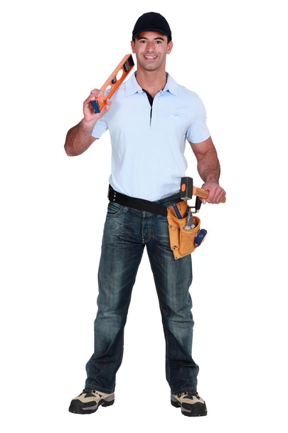 Builder holding spirit level and hammer - Zdjęcie, obraz