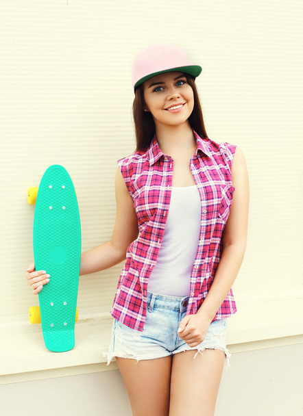 Fashion hipster cool girl in colorful pink clothes with skateboa - Zdjęcie, obraz