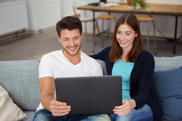 smiling couple browsing the internet - Фото, изображение