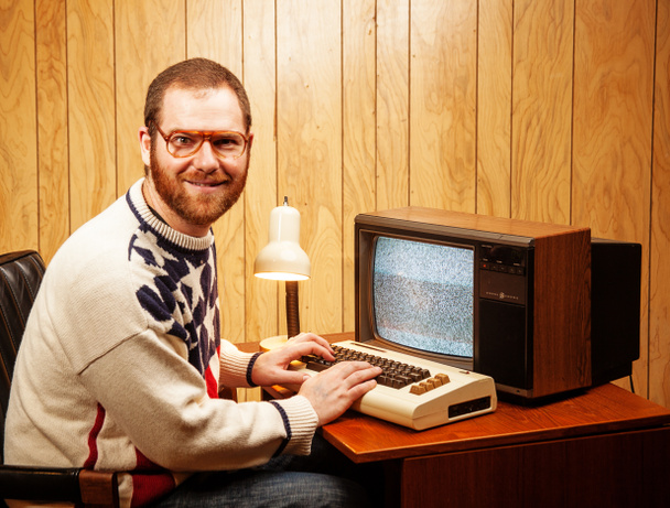 Guapo nerd adulto usando un vintage ordenador TV
 - Foto, Imagen