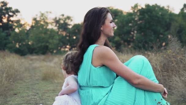 matka i jej córeczka siedzi powrotem do tyłu na polu jesień - Materiał filmowy, wideo