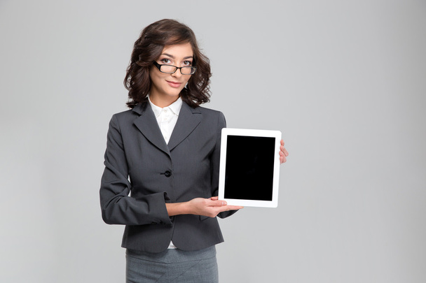 Pretty woman in glasses showing blank tablet computer screen - Fotoğraf, Görsel