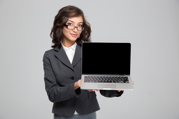 Confident pretty female showing blank laptop computer screen - Фото, изображение