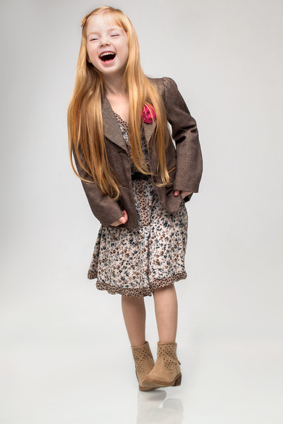 Beautiful little happy redhead girl standing posing in studio white background. - Fotó, kép