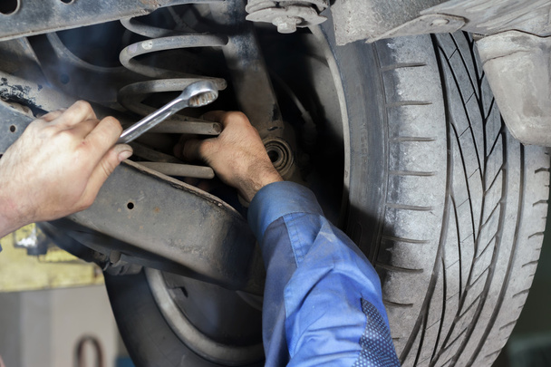mechanic fixes suspension - Φωτογραφία, εικόνα