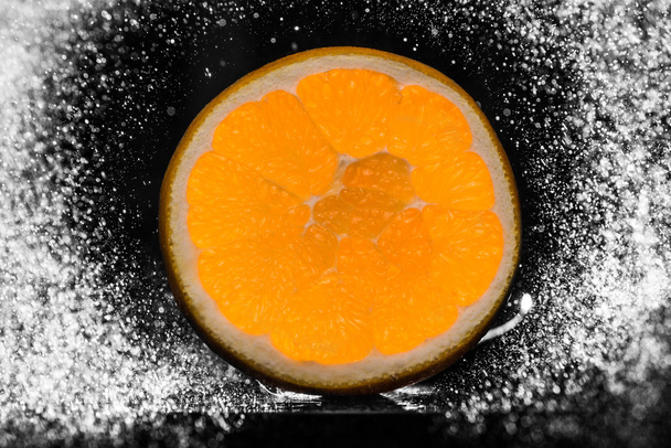 wet orange on a black background - Foto, Bild