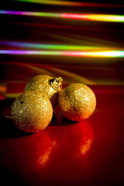 Three yellow christmas balls on red background - Photo, Image