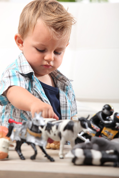 Young boy playing with a selection of toy figurines and animals - Photo, Image